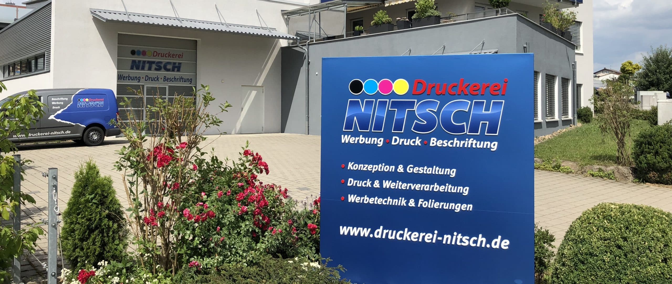 Firmenschild der Druckerei Nitsch vor dem Betriebsgebäude