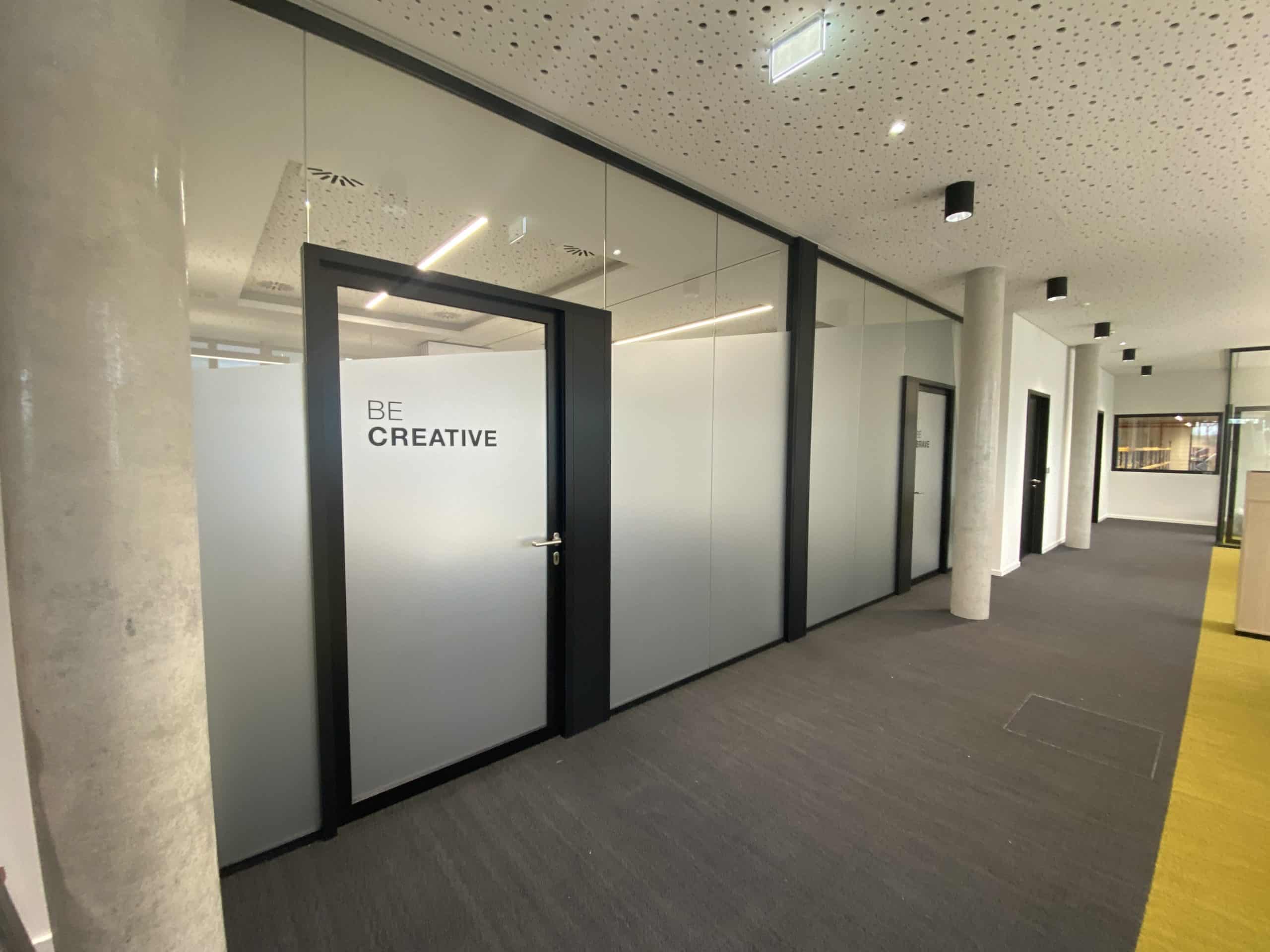 Folierte Glastüren in einem Büroflur mit Schriftzug „BE CREATIVE“