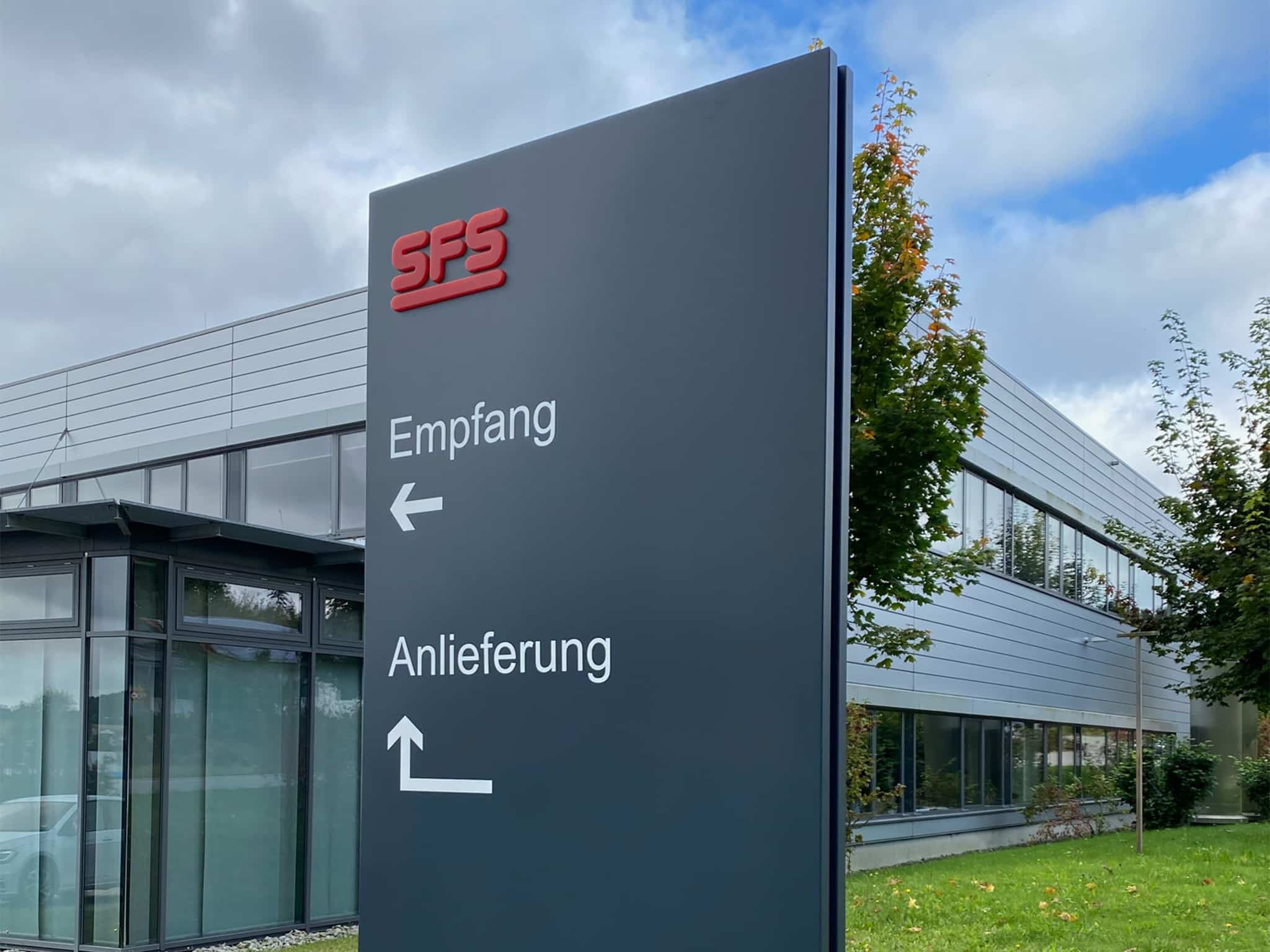 SPS-Wegweiser vor einem Firmengebäude