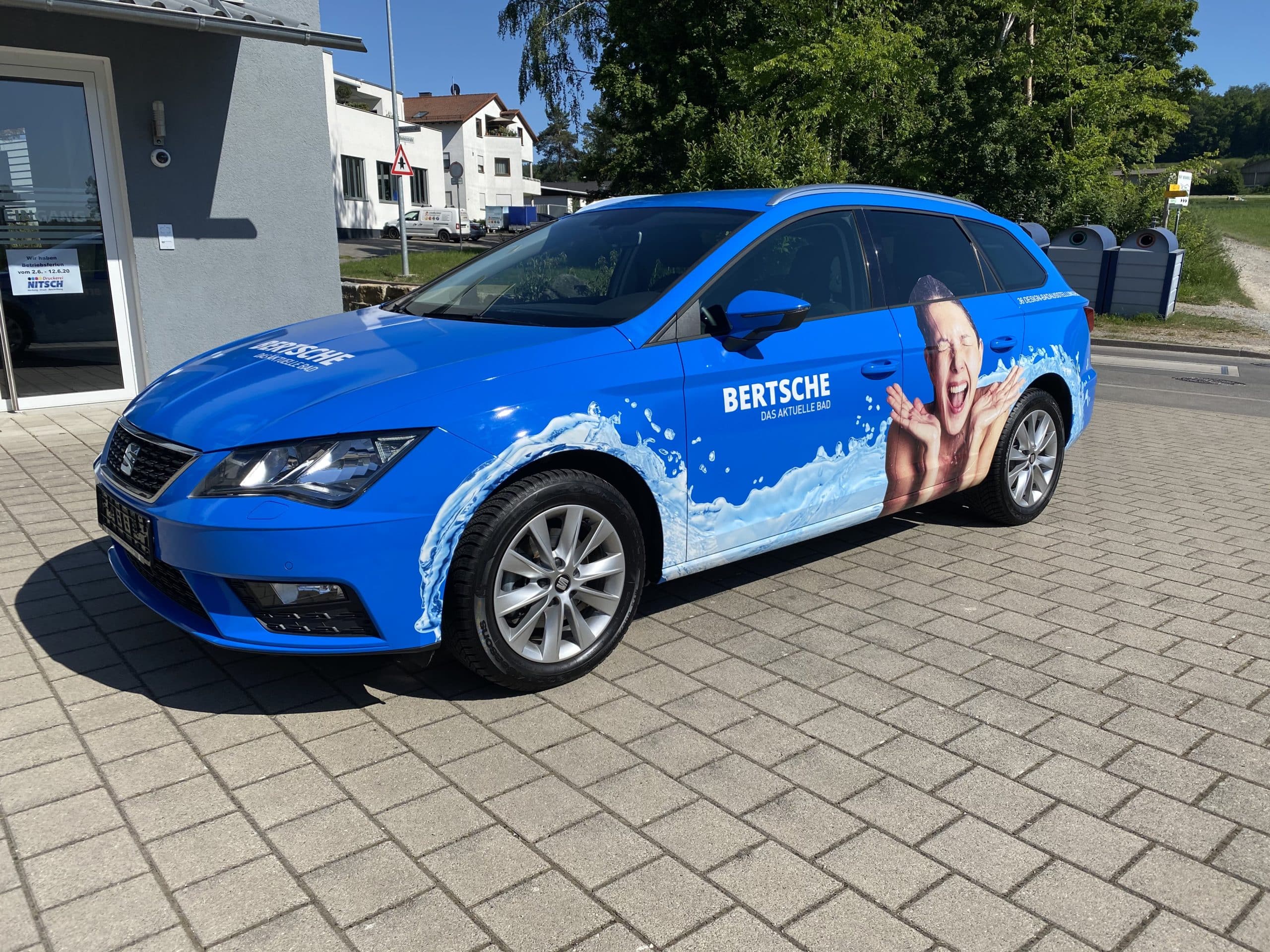 Blau folierter Pkw mit Bertsche-Werbung und Fotomotiv