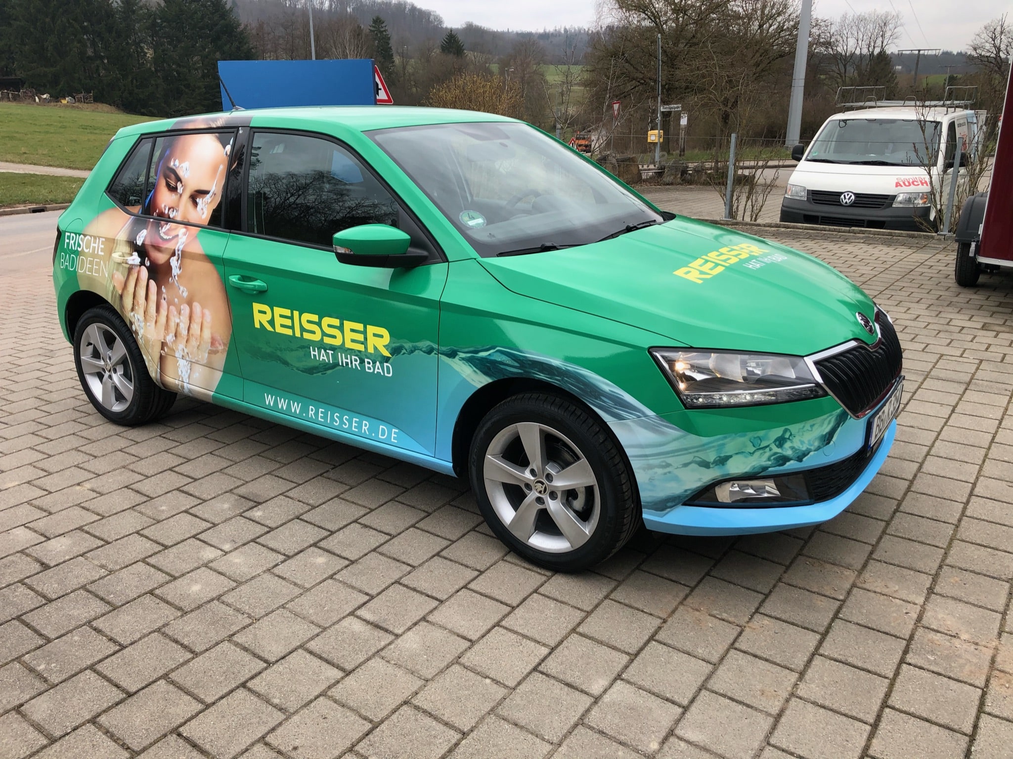 Grün folierter Pkw mit Reisser-Werbung