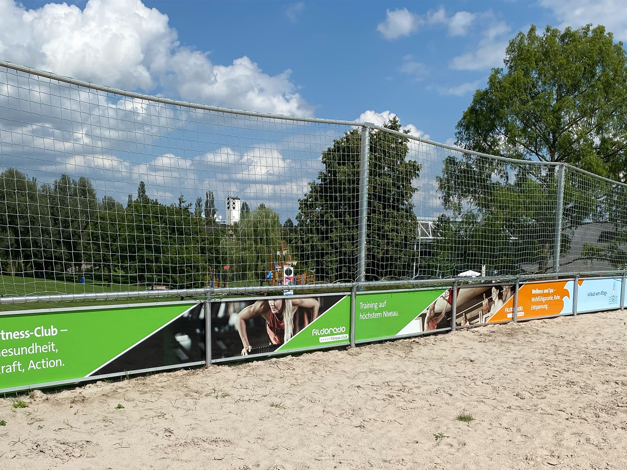 Werbebanner am Zaun eines Tennisplatzes