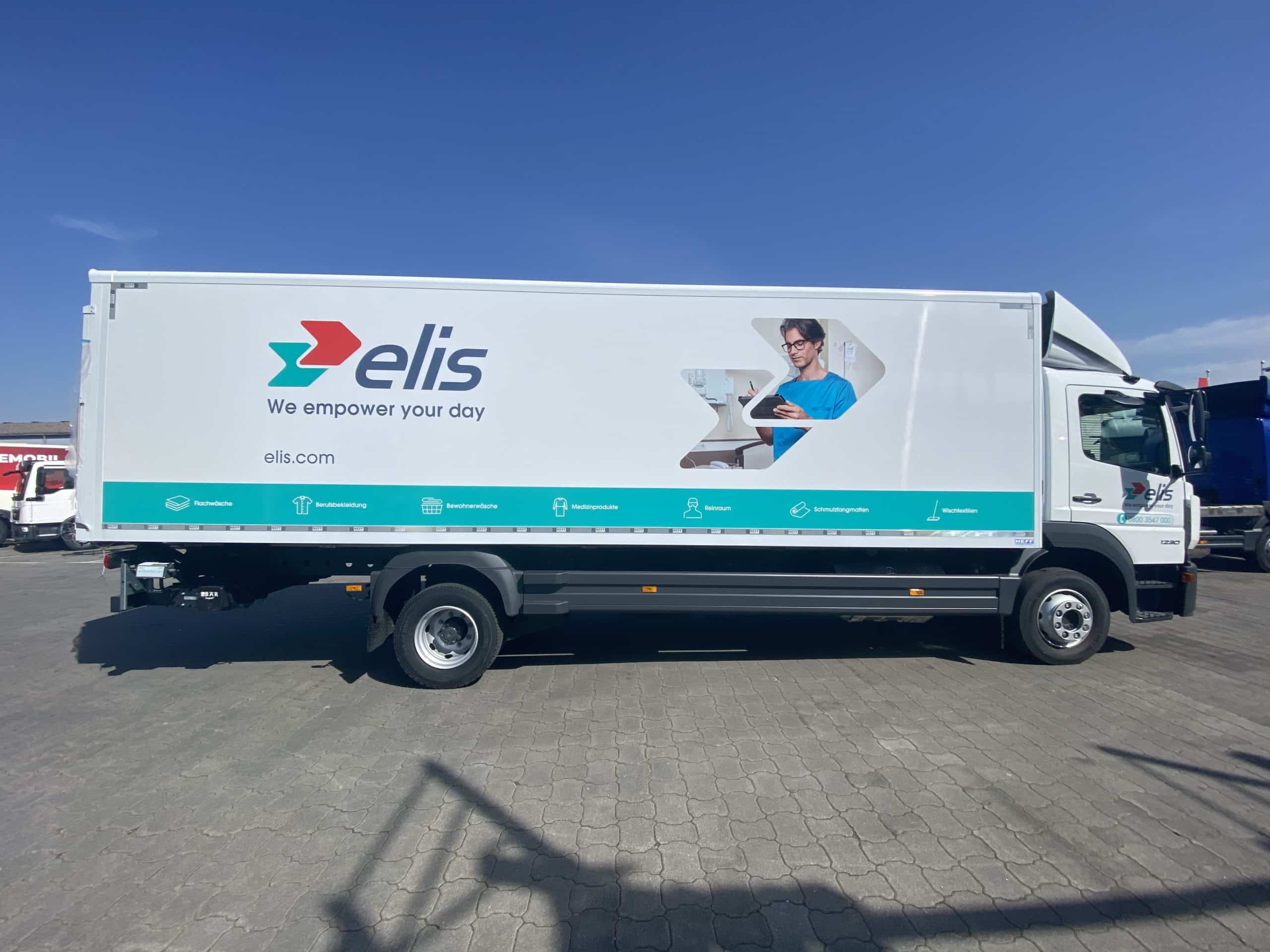 Weiß-türkis beschrifteter Lkw von Elis