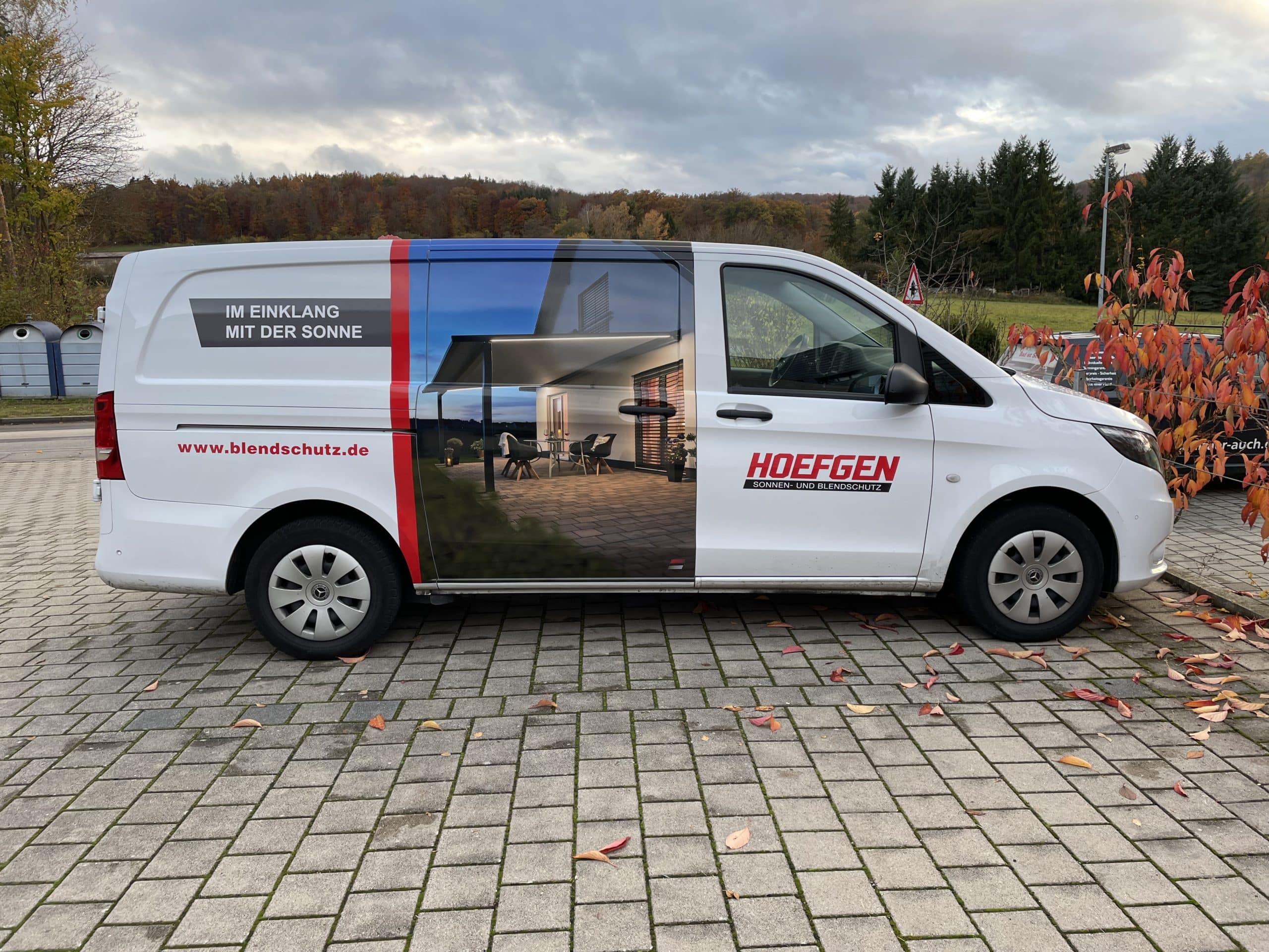 Weißer Transporter mit Hoefgen-Fahrzeugbeschriftung und Hausmotiv