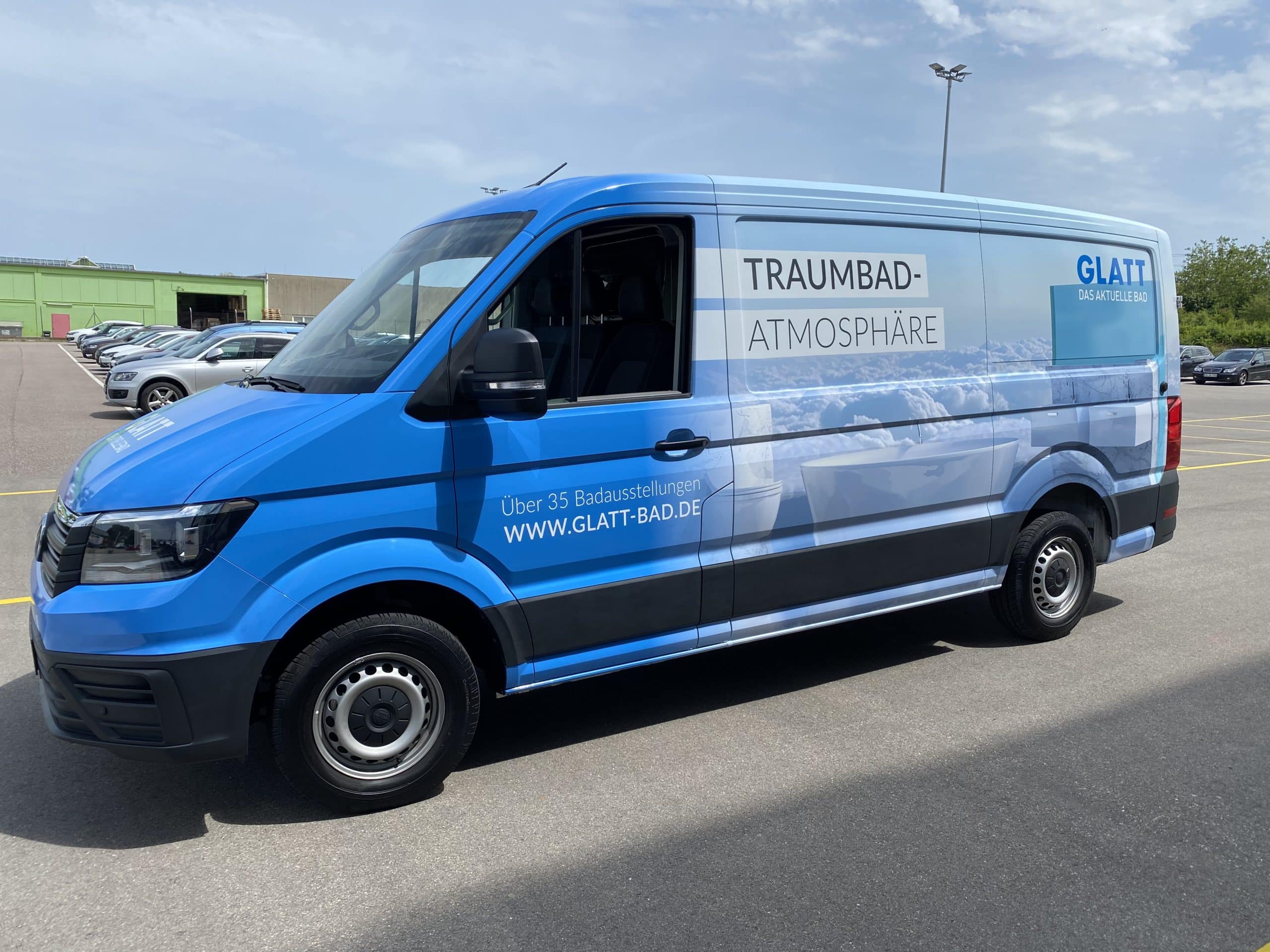 Blauer Transporter mit Traumbad-Werbung