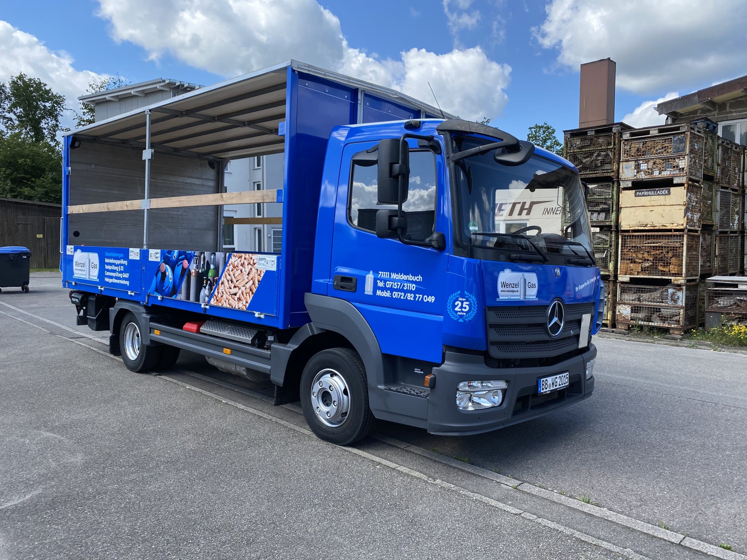 Blau beschrifteter Pritschen-Lkw eines Handwerksbetriebs